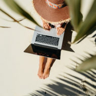 Woman working remotely on beach in shade