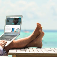 Man on laptop at the beach